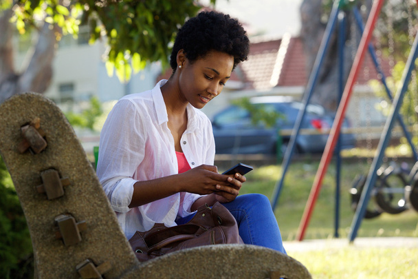 Jonge vrouw zittend op een bank - Foto, afbeelding