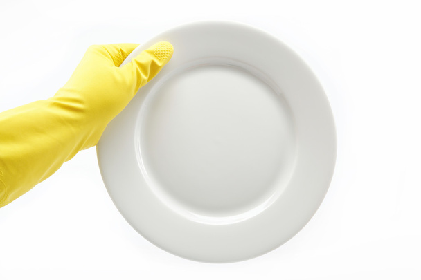 Hand in rubber glove with a plate on a white background. - Foto, Imagem