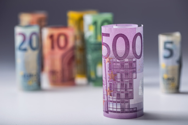 Several hundred euro banknotes stacked by value. Euro money concept. Rolls Euro  banknotes. Euro currency. Announced cancellation of five hundred euro banknotes. Banknotes stacked on each other in different positions. Toned photo - Photo, image