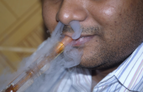 Людина Sheesha куріння
 - Фото, зображення