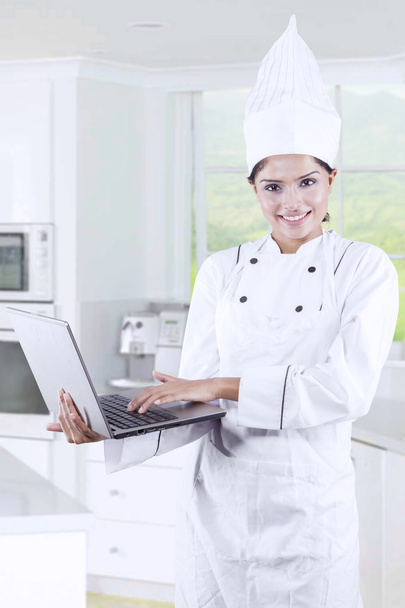 Female Chef Typing on A Laptop - Foto, afbeelding