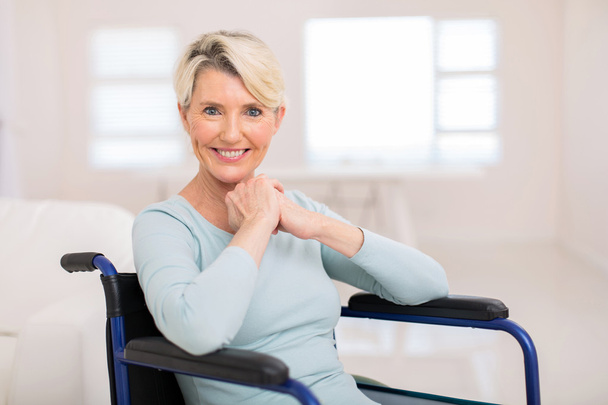 středního věku žena sedící na vozíku - Fotografie, Obrázek