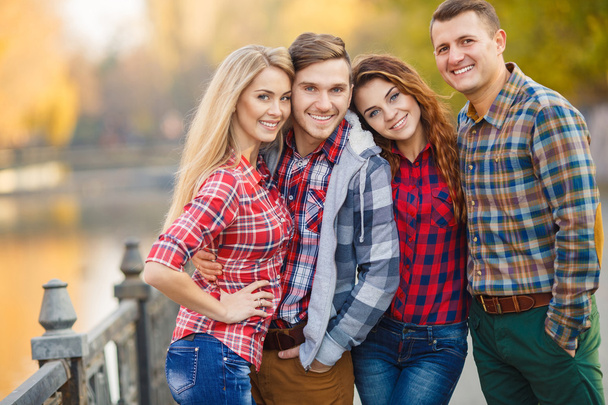 Two young couples spend time in the Park in early autumn - Foto, imagen