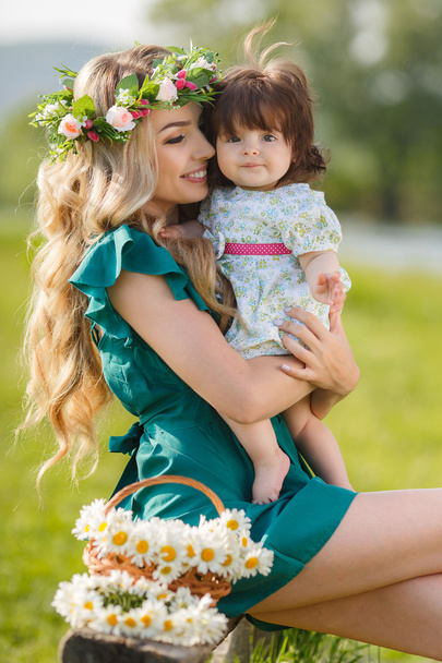 Madre feliz con la pequeña hija en el prado verde
 - Foto, Imagen
