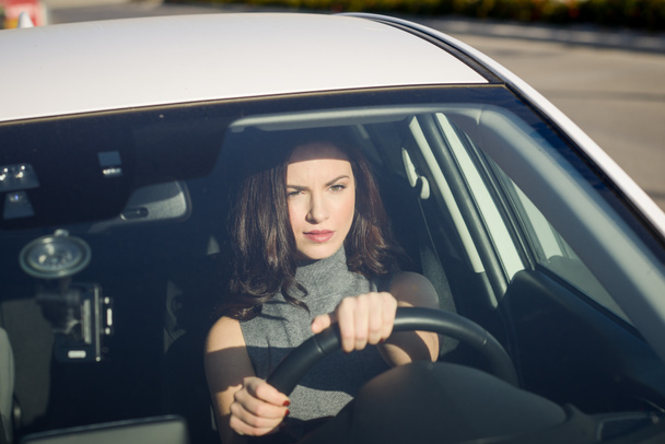 Bruneta žena, která řídila bílé auto v městském prostředí - Fotografie, Obrázek