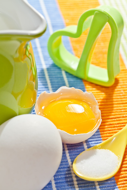 Виготовлення печива: свіжі яйця, зелений глечик, молоко, сіль і печиво для
 - Фото, зображення