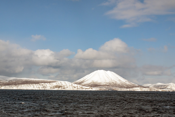 snowy volcano on the sea and blue sky background - Φωτογραφία, εικόνα