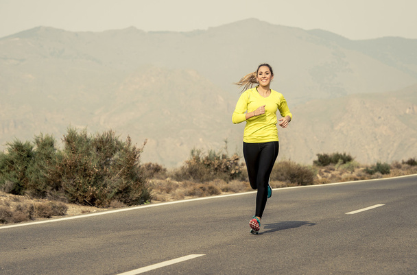 молодая привлекательная спортсменка бегает по пустынной горной асфальтовой дороге
 - Фото, изображение
