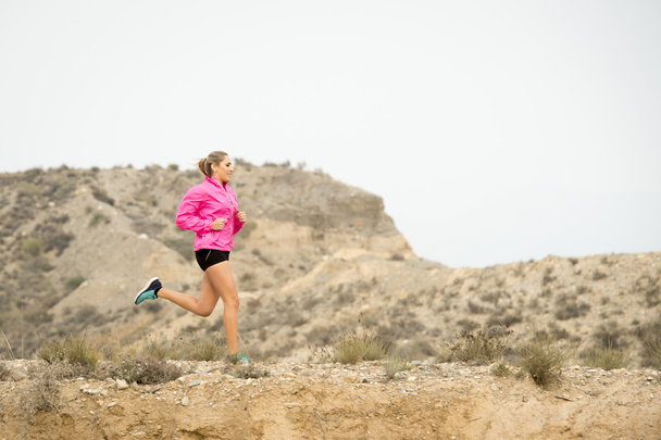 молодая спортивная женщина бежит по бездорожью грязная дорога с сухим пейзажем пустыни подготовки трудно
 - Фото, изображение
