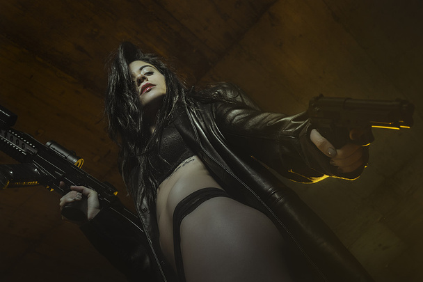violence, brunette girl dressed in black leather with guns and p - Φωτογραφία, εικόνα