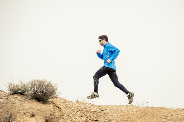 乾燥砂漠の風景の背景にハードにトレーニングと道路歩道汚れた道路で走っているスポーツ人 - 写真・画像