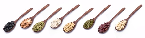 Colección de frutos secos, semillas en cuchara de madera sobre fondo blanco
 - Foto, Imagen