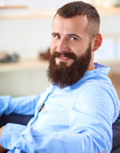 Young businessman sitting on chair in office - Foto, Bild