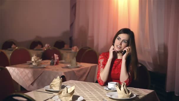 dziewczynka kobieta rozmawia smartphone siedząc w kawiarni wieczorem - Materiał filmowy, wideo