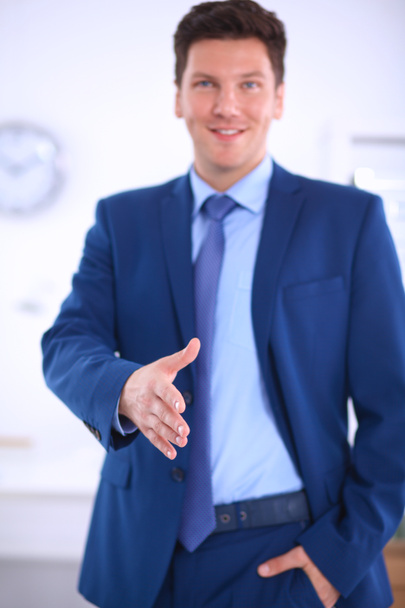 Business and office concept - handsome businessman with open hand ready for handshake - Foto, Imagem