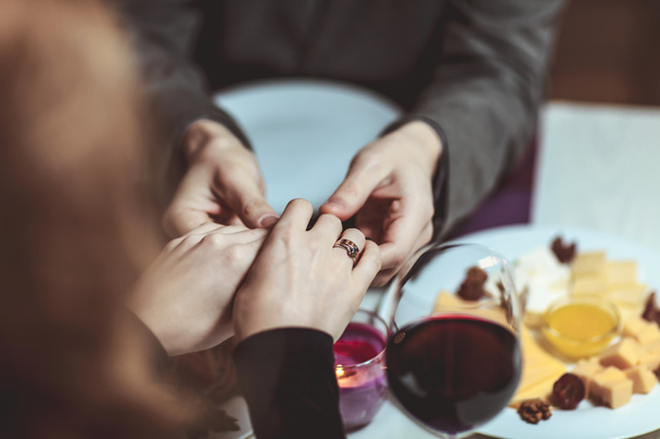 Beautiful young couple with glasses of red wine in luxury restaurant - Foto, afbeelding