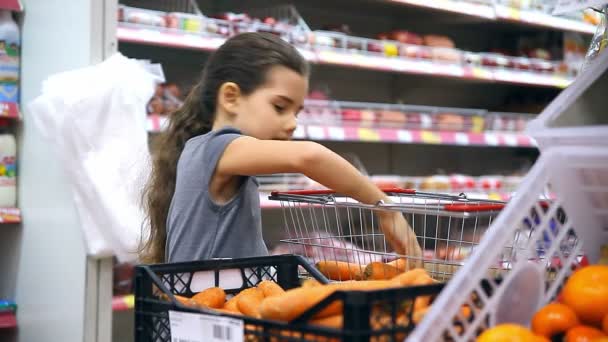 dospívající dívka s do supermarketu koupit jídlo mrkev zelenina - Záběry, video