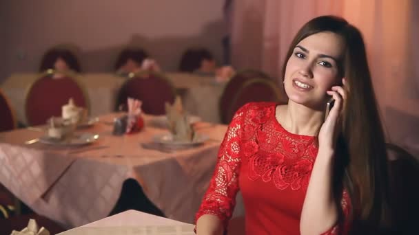 Mädchen telefoniert mit Smartphone Frau sitzt im Abendcafé - Filmmaterial, Video