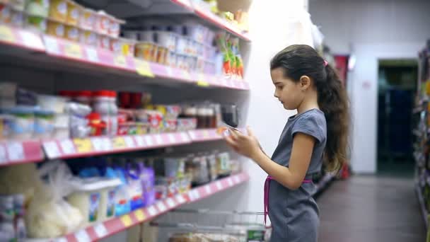 κορίτσι έφηβος στο σουπερμάρκετ για να αγοράσει τα τρόφιμα γαλακτοκομικά γιαούρτι - Πλάνα, βίντεο