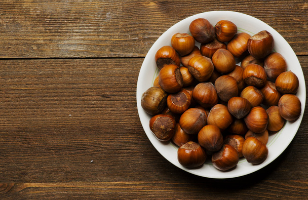 pile of hazelnuts in shell on wooden table  - Foto, imagen