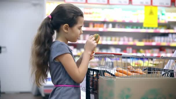 dospívající dívka s do supermarketu koupit mrkev zelenina potraviny - Záběry, video