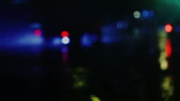 kropla deszczu z ulicy kolorowe światła ruchu w nocy rozmycie bokeh streszczenie tło odcień, chłodny chłód mokrego deszcz sezon koncepcja - Materiał filmowy, wideo