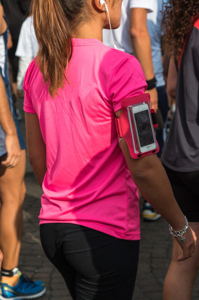 Menina com T-shirt rosa e Smartphone Capa de braçadeira à espera de Ru
 - Foto, Imagem