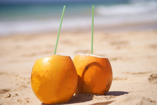 Two yellow coconuts on the sand - Fotoğraf, Görsel