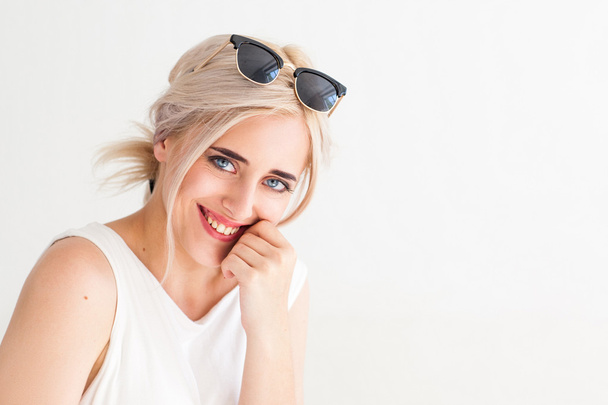 улыбающаяся молодая блондинка в солнечных очках
 - Фото, изображение