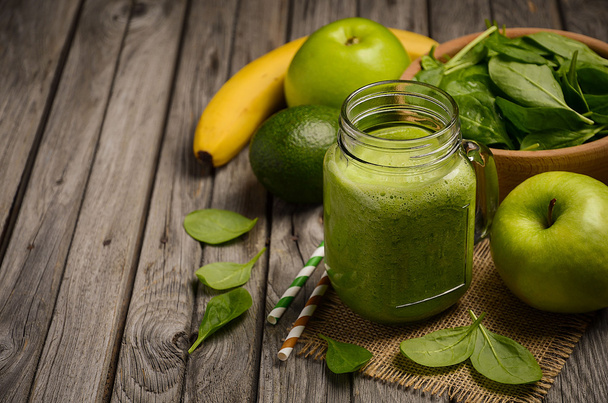 Zelený koktejl s jablko, banán, avokádo a špenát na dřevěný rustikální pozadí. - Fotografie, Obrázek