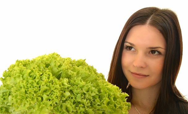 Happy young woman holding green lettuce and smiling, over white background - Foto, imagen