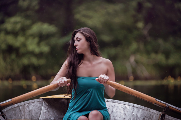 pelo largo morena en un vestido sentado en el barco
 - Foto, imagen
