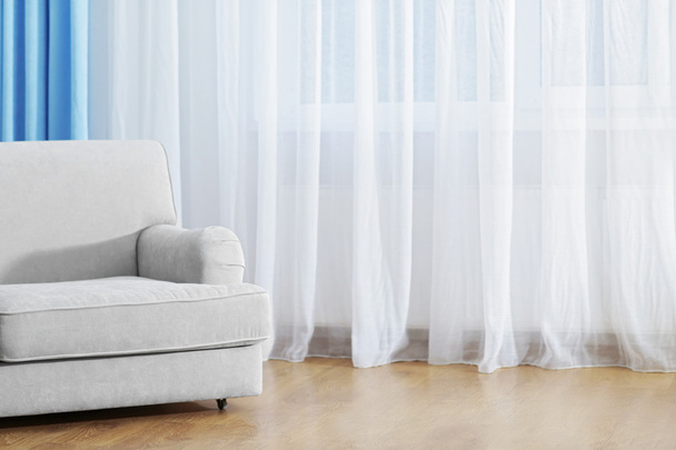 Sofá en la habitación con cortinas
 - Foto, imagen