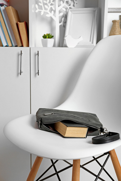 handbag with book on white chair - 写真・画像