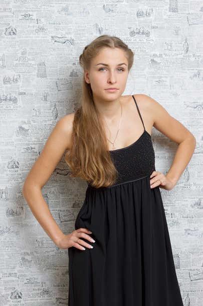 Beautiful girl in a dress near the wall - Fotó, kép