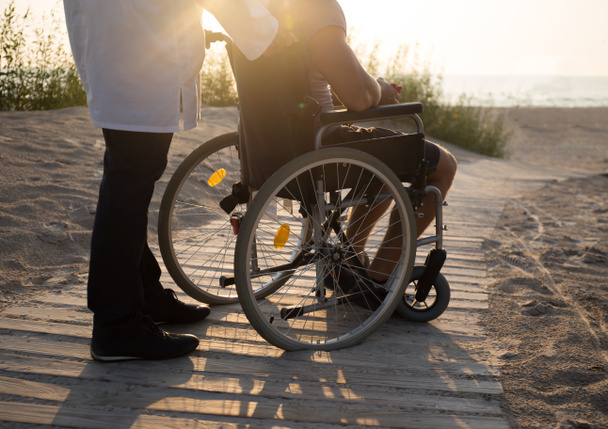 Muž ve vozíku a lékař - Fotografie, Obrázek