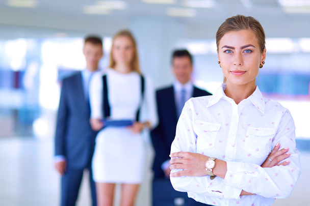 Portrait of young businesswoman in office with colleagues in the background - Photo, Image