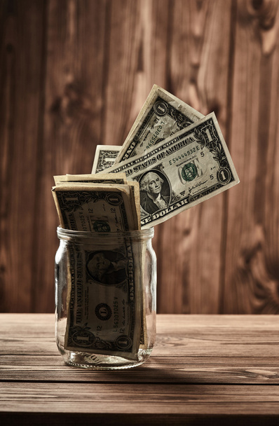 Savings. Dollars in glass jar - Foto, afbeelding