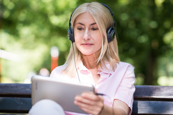 Mature woman listening music - Foto, Imagen