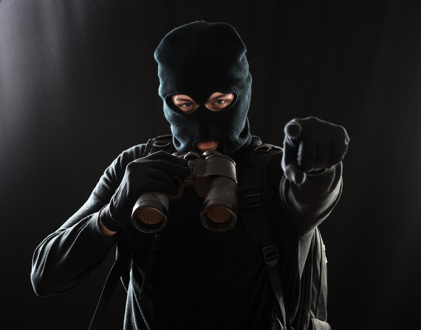 Thief in black clothes using binoculars - Photo, image
