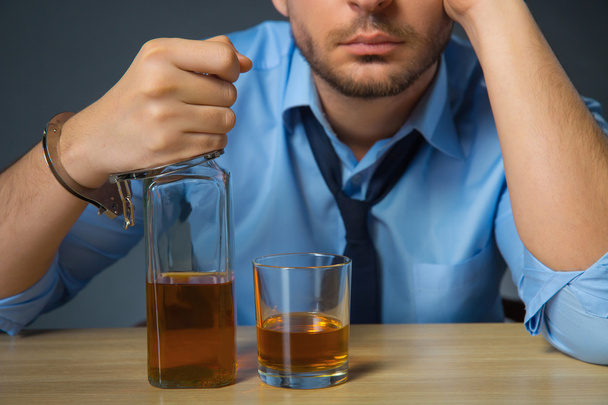 Drunk man drinking alcohol at the table - Фото, зображення