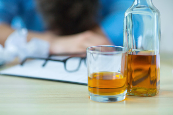 Drunk man drinking alcohol while working - Foto, Imagem