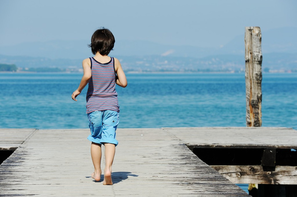 Little boy walking on dock - Photo, image