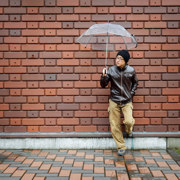 Azjatyckiej człowiek w brązowy płaszcz z jasne parasol - Zdjęcie, obraz