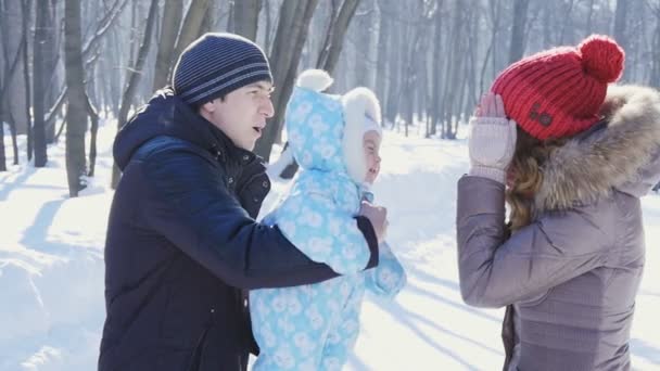 Ojciec i matka spacer w parku z dzieckiem w zimie slowmotion - Materiał filmowy, wideo