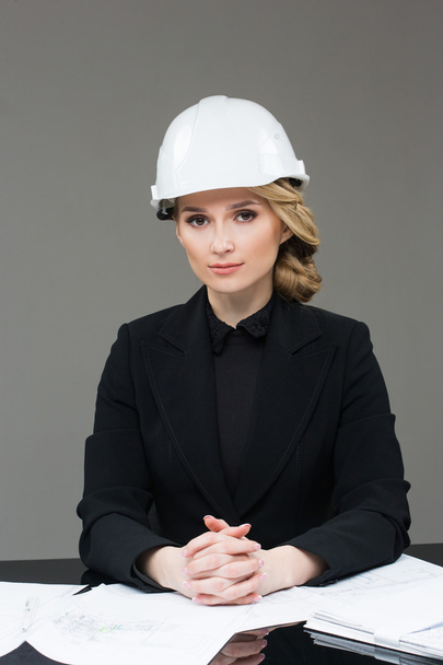 Woman architect with drawings. Beautiful girl in a building helmet - Fotografie, Obrázek