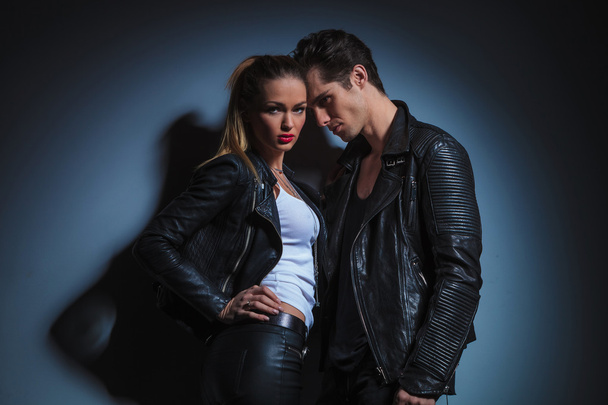 fashion couple in leather is posing in studio background - Zdjęcie, obraz