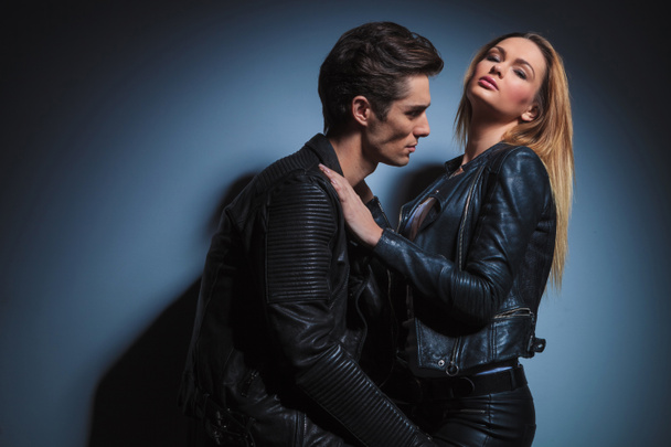 couple in black leather embracing each other in studio backgroun - Φωτογραφία, εικόνα