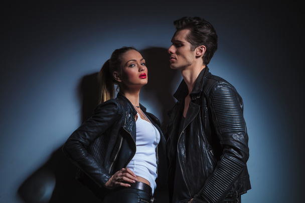 man looking down on sexy woman in leather jacket - 写真・画像