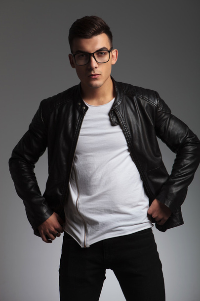 model wearing glasses in studio fixing his jacket - Foto, afbeelding